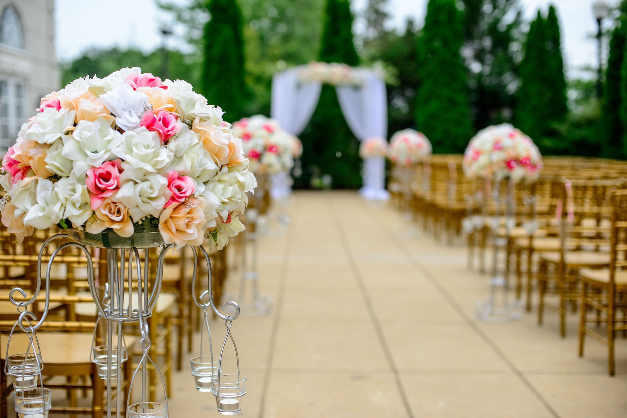 A flower-lined wedding aisle set for an outdoor ceremony